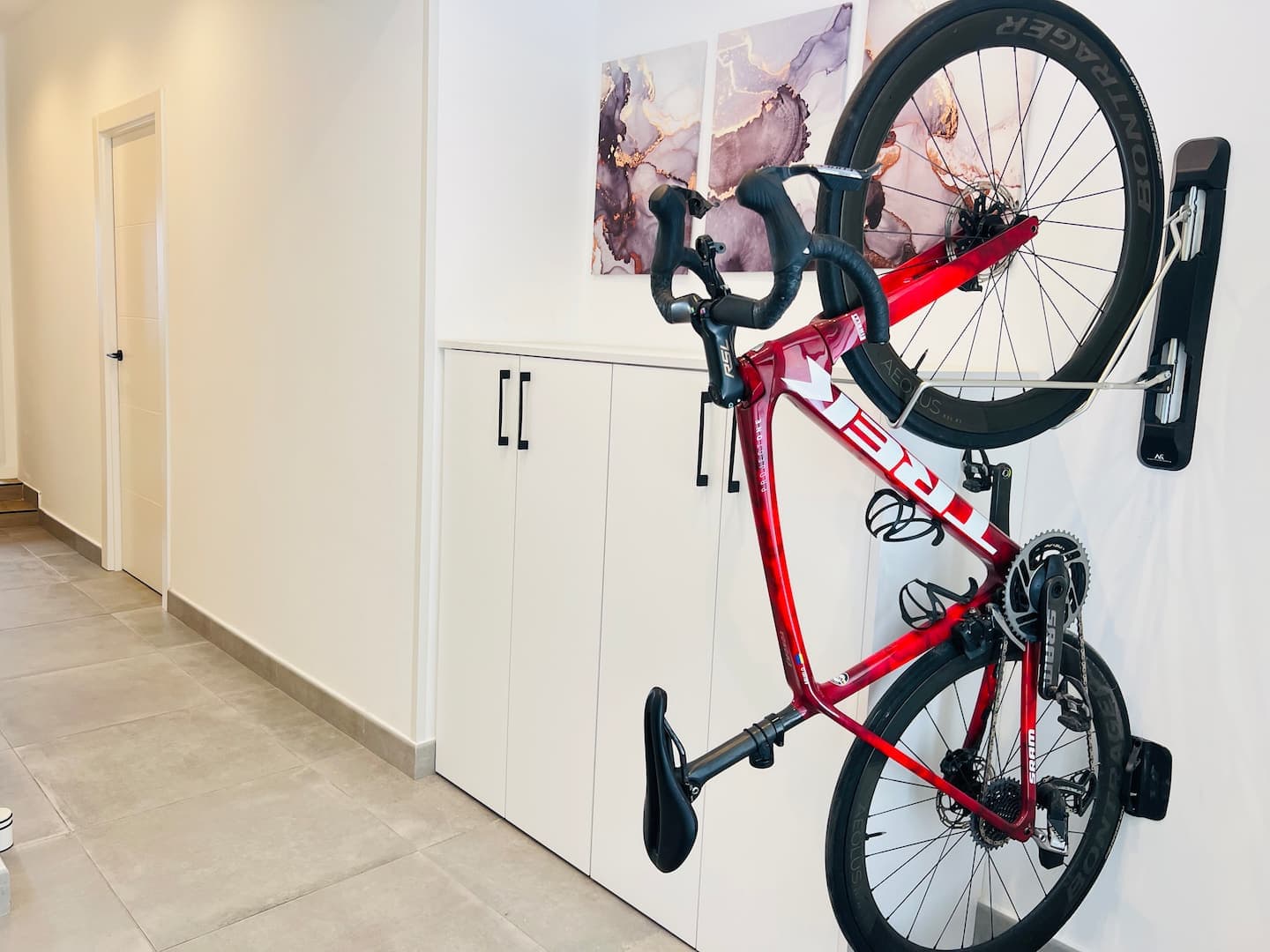 Road bike on the wall rack inside the house